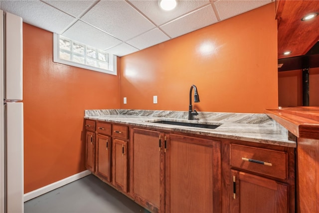 kitchen featuring white fridge, concrete floors, sink, and a paneled ceiling