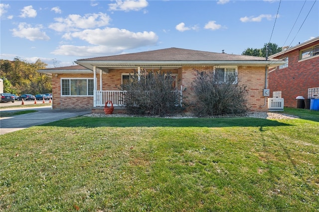 ranch-style home with central air condition unit, a front yard, and covered porch