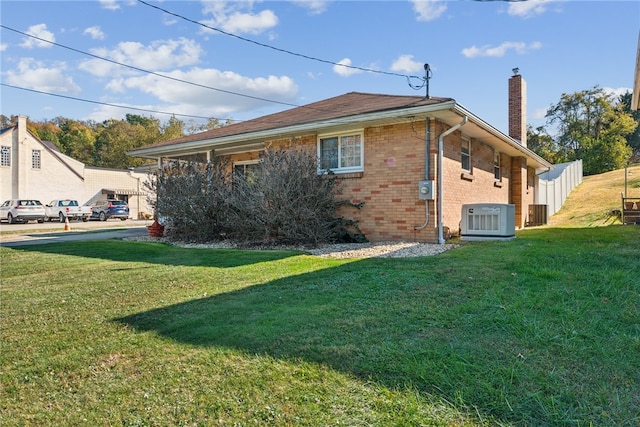 view of property exterior with central AC and a lawn