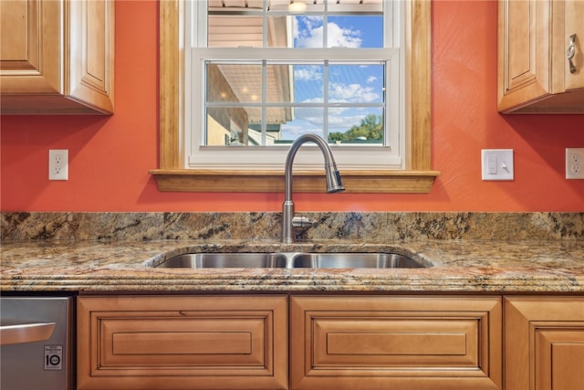 kitchen featuring light stone countertops and sink