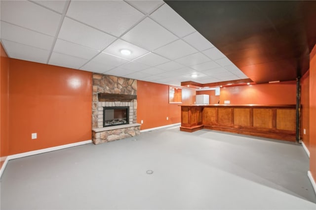 basement featuring a drop ceiling and a fireplace