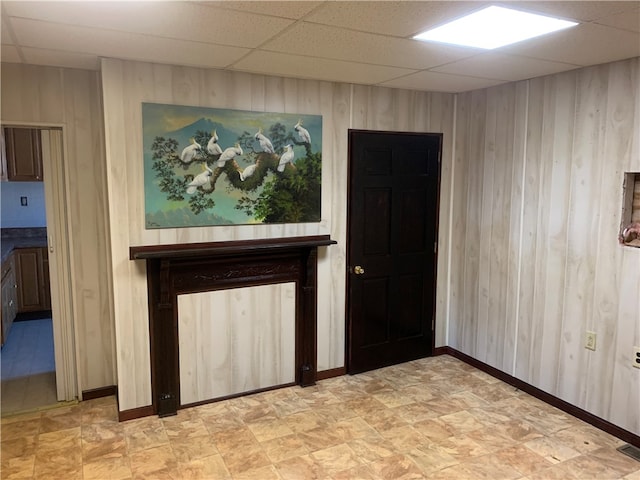 spare room with wood walls and a paneled ceiling