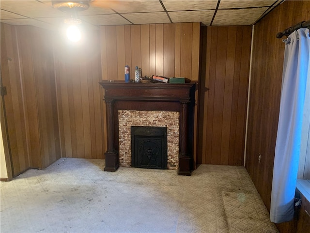 living room with a paneled ceiling, wooden walls, and a fireplace