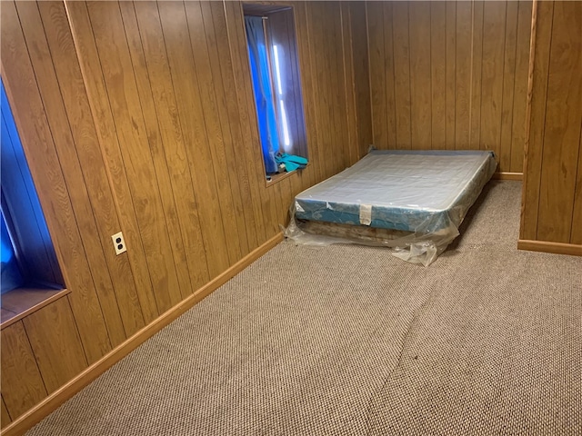 unfurnished bedroom with wooden walls and carpet