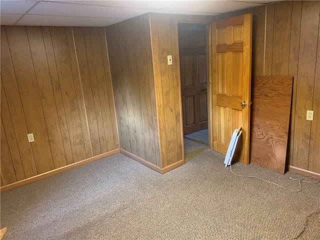 spare room with light carpet and wood walls