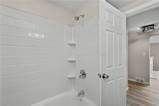 bathroom with tiled shower / bath combo and hardwood / wood-style floors