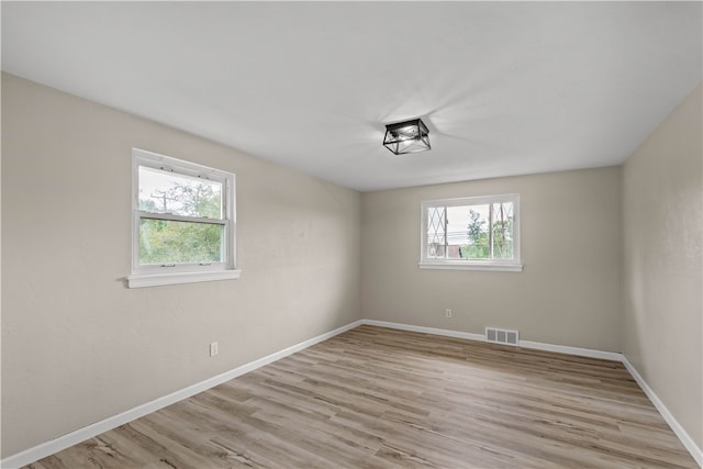 spare room with light hardwood / wood-style flooring and a wealth of natural light