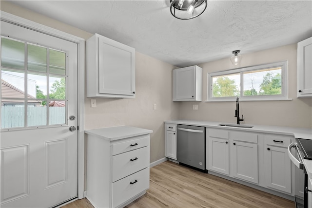 kitchen with stainless steel appliances, sink, light wood-type flooring, white cabinetry, and a textured ceiling