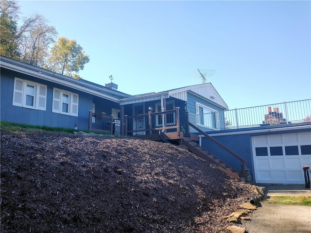 view of property exterior with a deck and a garage