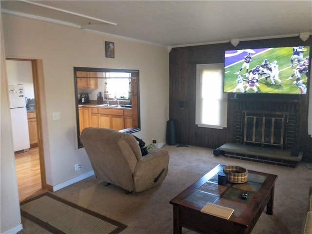 living room with light carpet, ornamental molding, sink, and a brick fireplace