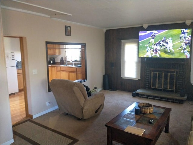 living room featuring a fireplace, light carpet, and crown molding