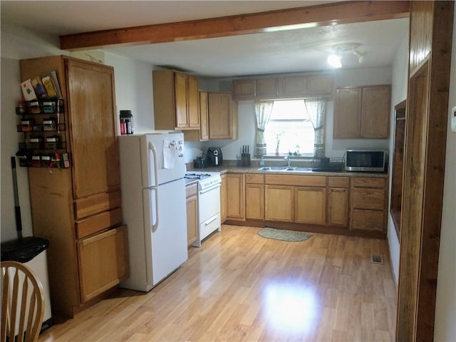 kitchen featuring white appliances, beam ceiling, light hardwood / wood-style flooring, and sink