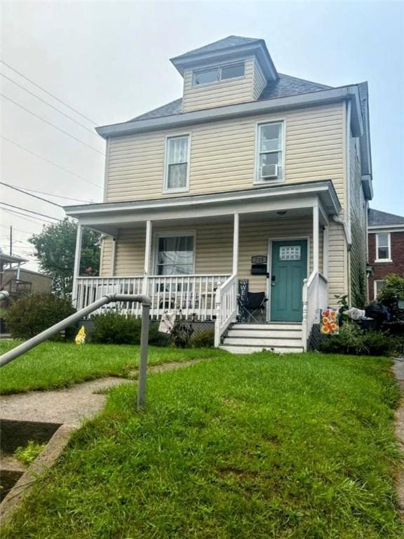 traditional style home featuring covered porch, a front lawn, and cooling unit