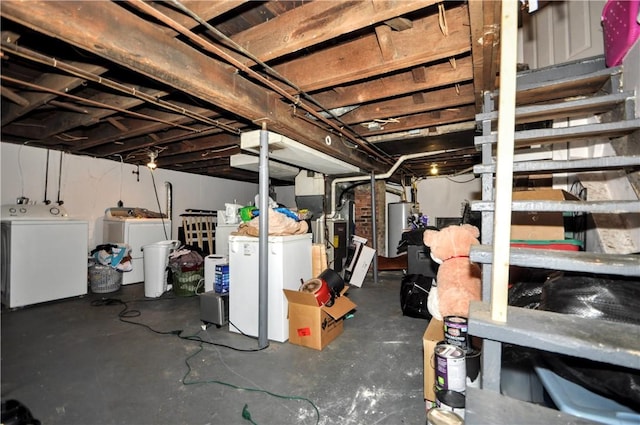 unfinished below grade area featuring independent washer and dryer, water heater, and fridge