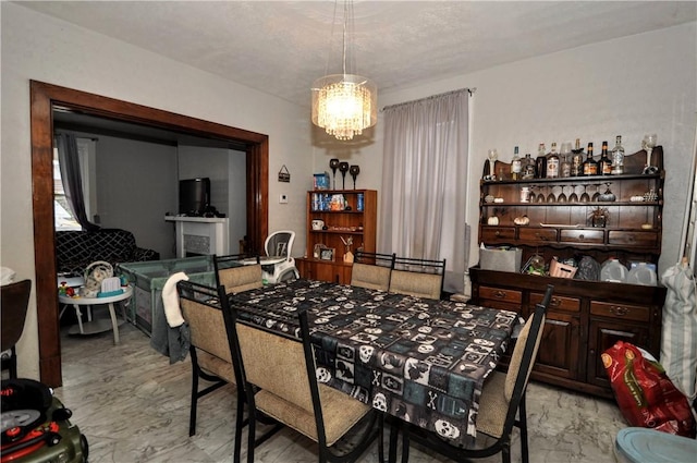 dining room featuring marble finish flooring and a chandelier