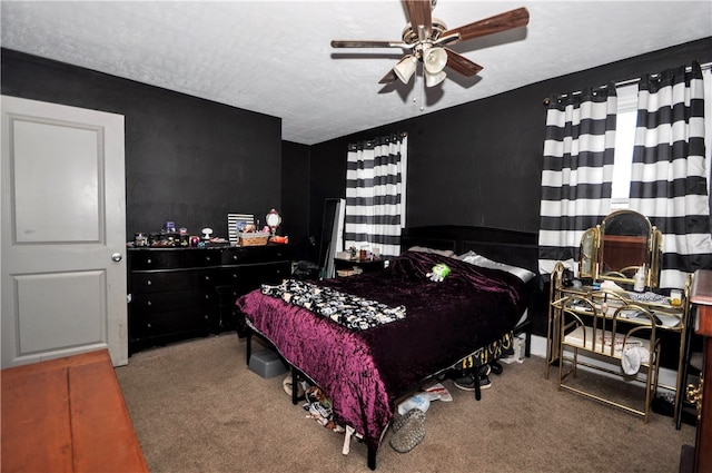 carpeted bedroom featuring ceiling fan and a textured ceiling