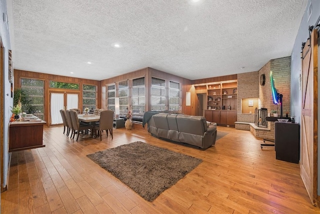 living room with a textured ceiling and light hardwood / wood-style flooring