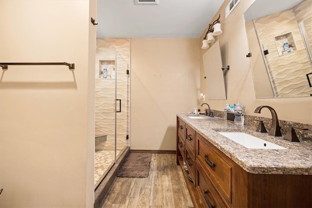 bathroom featuring vanity, hardwood / wood-style floors, and a shower with shower door