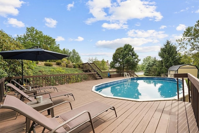 view of swimming pool with a deck and a storage unit