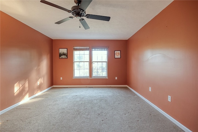 spare room featuring light carpet, a textured ceiling, and ceiling fan