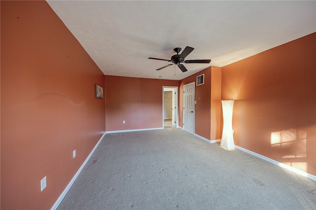 spare room featuring a textured ceiling, carpet floors, and ceiling fan