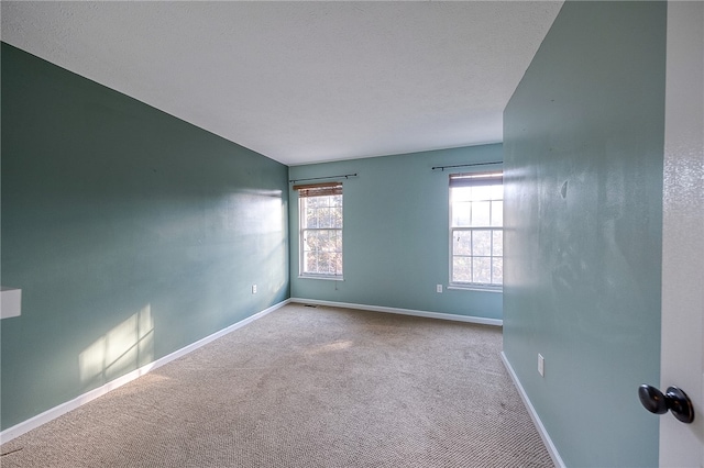 unfurnished room featuring light carpet