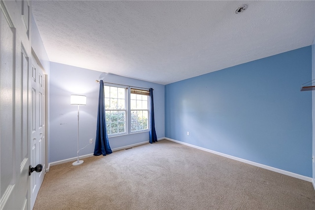 carpeted spare room with a textured ceiling