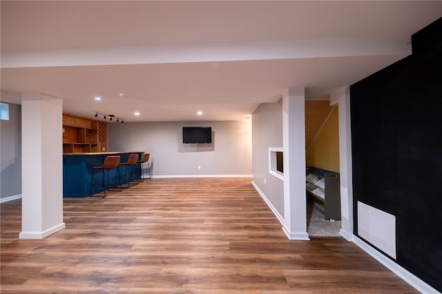 basement with hardwood / wood-style floors and indoor bar