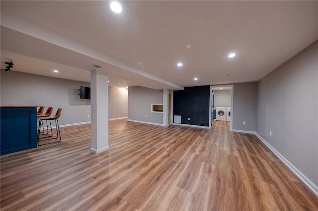 unfurnished living room with light hardwood / wood-style flooring and independent washer and dryer