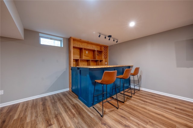 bar featuring light hardwood / wood-style flooring and track lighting