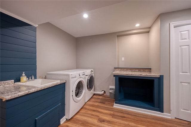 laundry area with sink, light hardwood / wood-style flooring, and washer and dryer