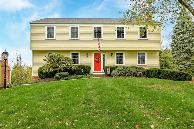 colonial inspired home with a front lawn