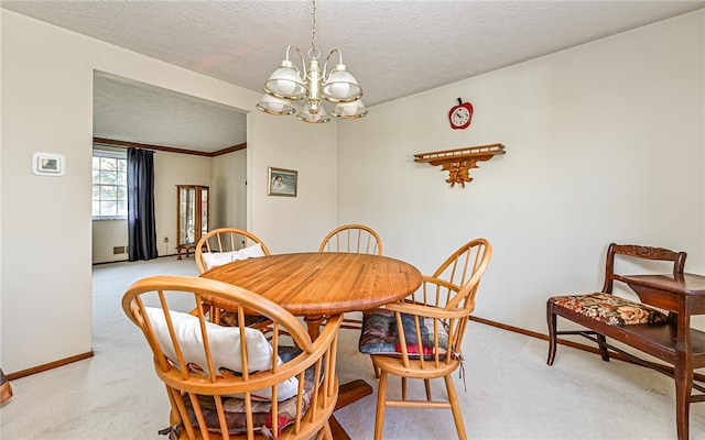 dining room featuring light colored carpet, a textured ceiling, a chandelier, and ornamental molding