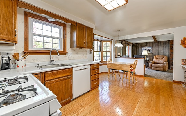 kitchen featuring hanging light fixtures, a wealth of natural light, sink, and white appliances