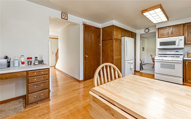 kitchen featuring white appliances and light hardwood / wood-style floors