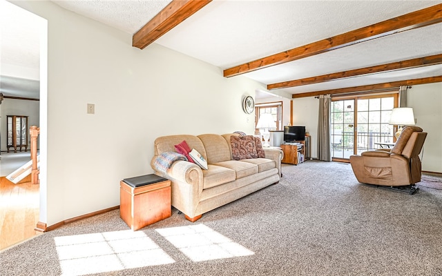 carpeted living room featuring beam ceiling and a textured ceiling