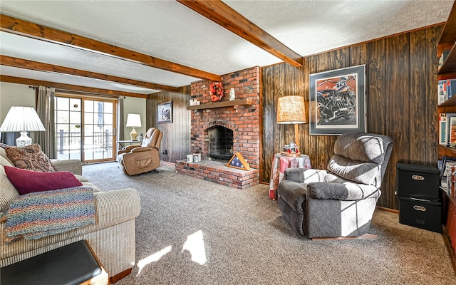 carpeted living room with wood walls, beamed ceiling, a fireplace, and a textured ceiling