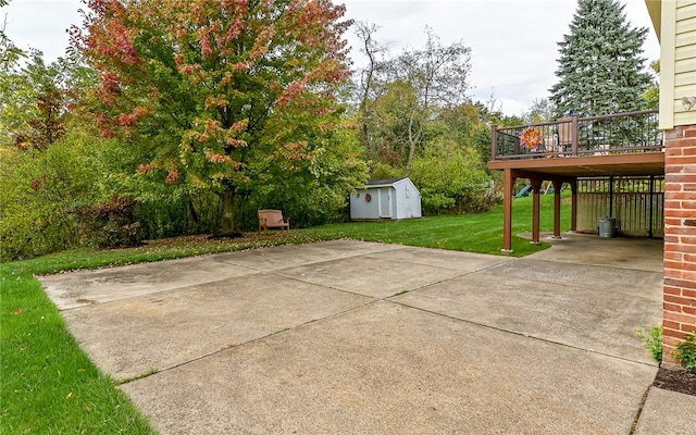 view of patio with a shed, a wooden deck, and a carport