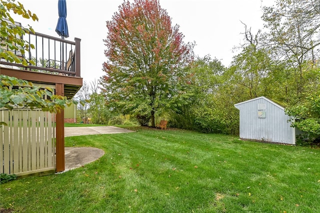 view of yard featuring a shed, a patio area, and a wooden deck