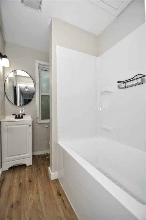 bathroom with vanity, wood-type flooring, and a washtub