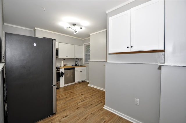 kitchen with crown molding, sink, white cabinetry, light wood-type flooring, and appliances with stainless steel finishes