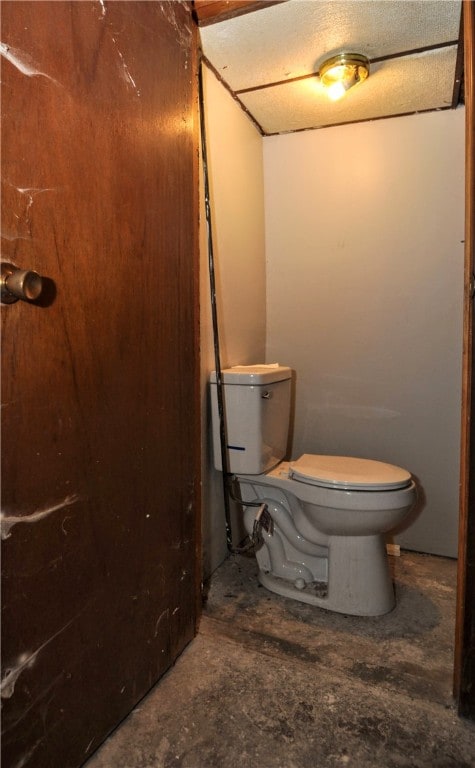 bathroom featuring toilet and concrete flooring