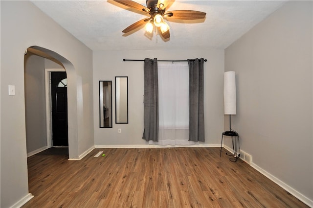 empty room with ceiling fan, a textured ceiling, and hardwood / wood-style floors