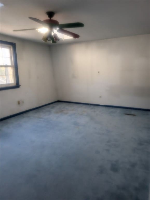 unfurnished room featuring ceiling fan and concrete flooring