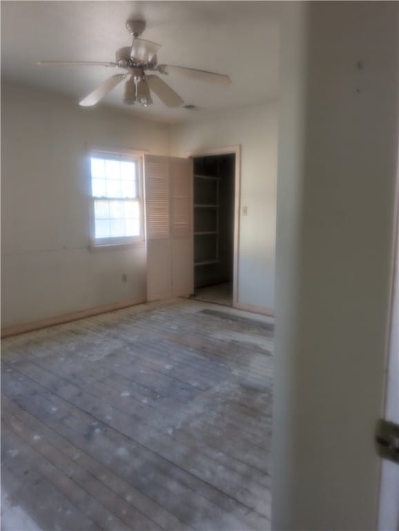 empty room with ceiling fan and wood-type flooring