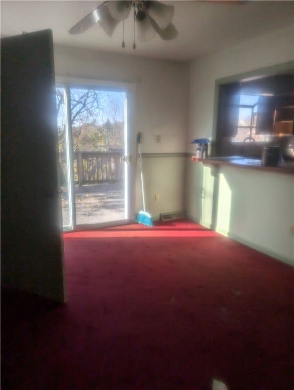 spare room with carpet flooring, ceiling fan, and a healthy amount of sunlight