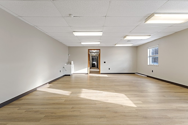 spare room featuring light hardwood / wood-style floors and a drop ceiling