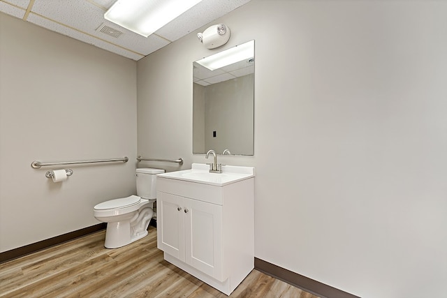 bathroom with toilet, vanity, and wood-type flooring