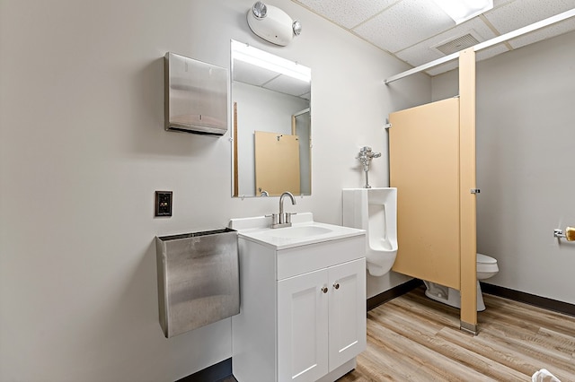 bathroom with vanity, hardwood / wood-style floors, a paneled ceiling, and toilet