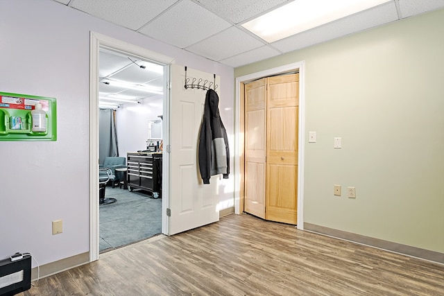 interior space with hardwood / wood-style flooring and a drop ceiling